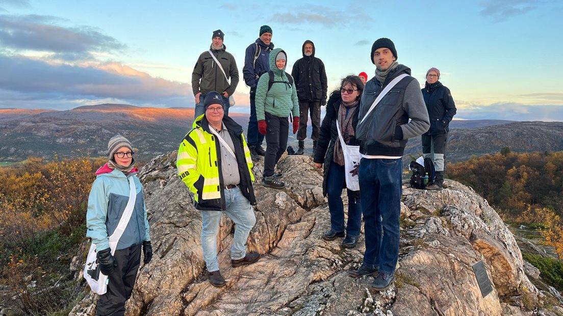 En griuppe mennesker samlet på fjellet Lille Raipas i Alta som Alta som utgjør et av punktene på Struves Meridianbue. Foto: Louise Galapati Larsen