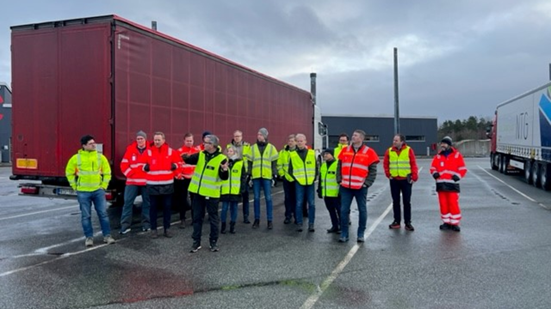 Personer fra prosjektgruppe foran tollstasjon og trailer. Foto: Viken fylkeskommune