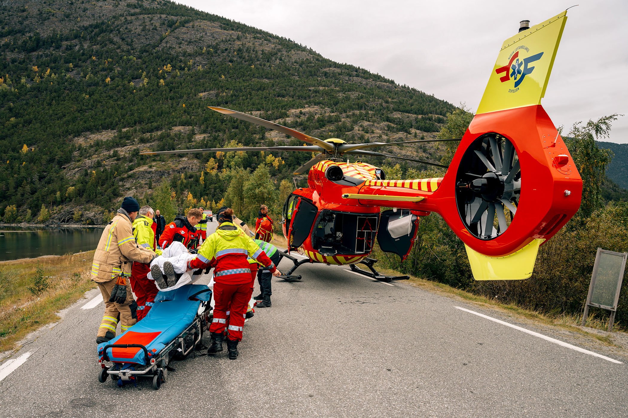 Mannskap b&aelig;rer b&aring;re inn i ventende ambulansehelikopter