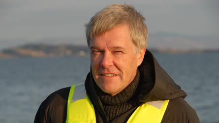 Portrettfoto av Jon Arne Grøttum med rød sommersol i ansiktet. Foto: Sjømat Norge