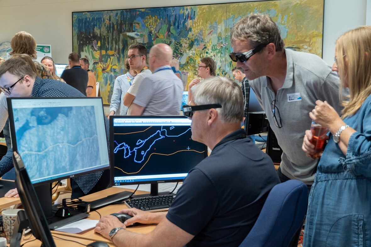 Tre mennesker med 3D-briller ser p&aring; en skjerm med kart. Foto: Louise Larsen
