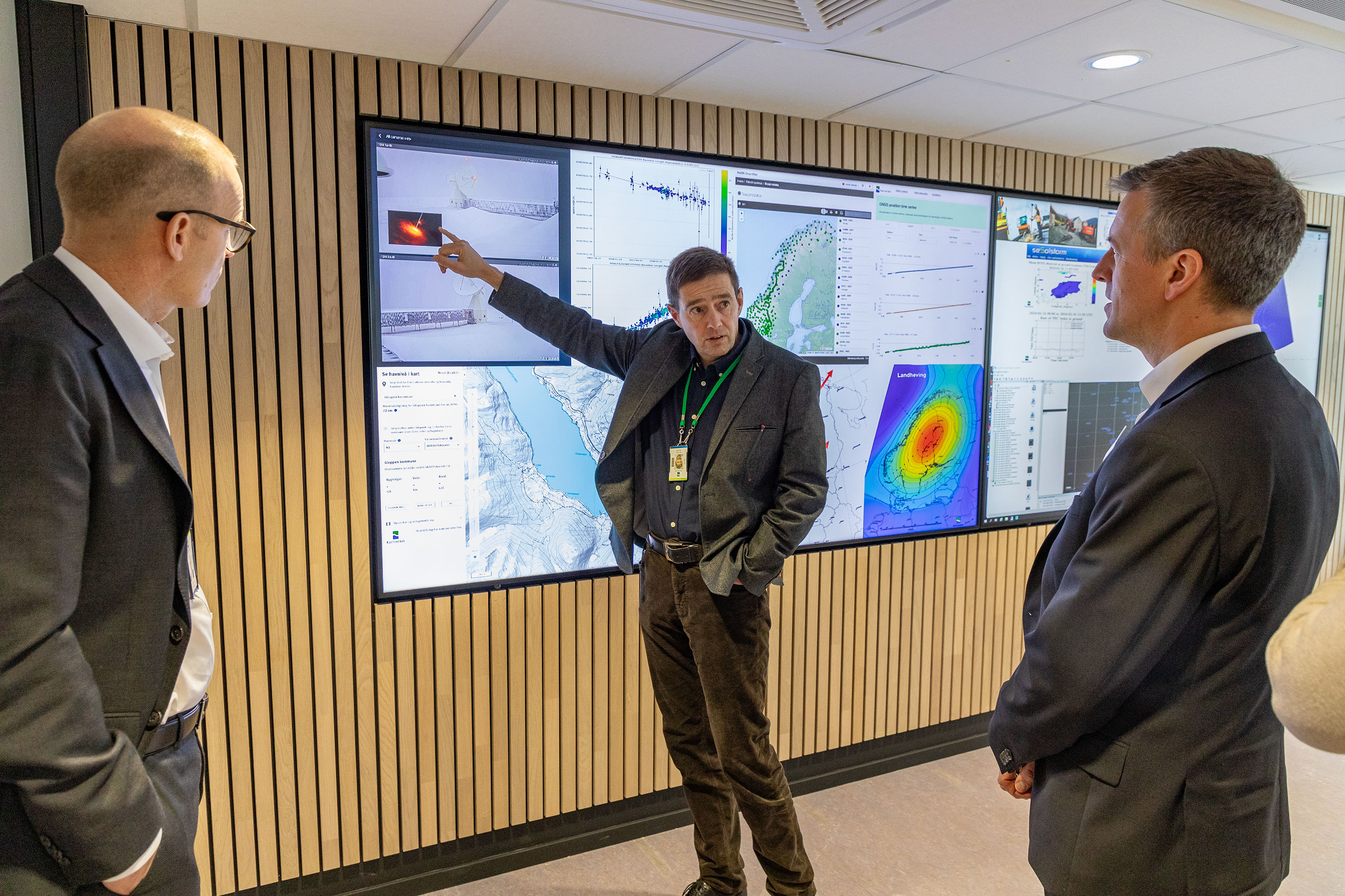 Geodesidirekt&oslash;r Per-Erik Opseth og statsr&aring;d Erling Sande foran store dataskjermer i Kartverkets kontrollsenter for geodesi. Foto: &Aring;sgeir St&oslash;rdal/ Kartverket