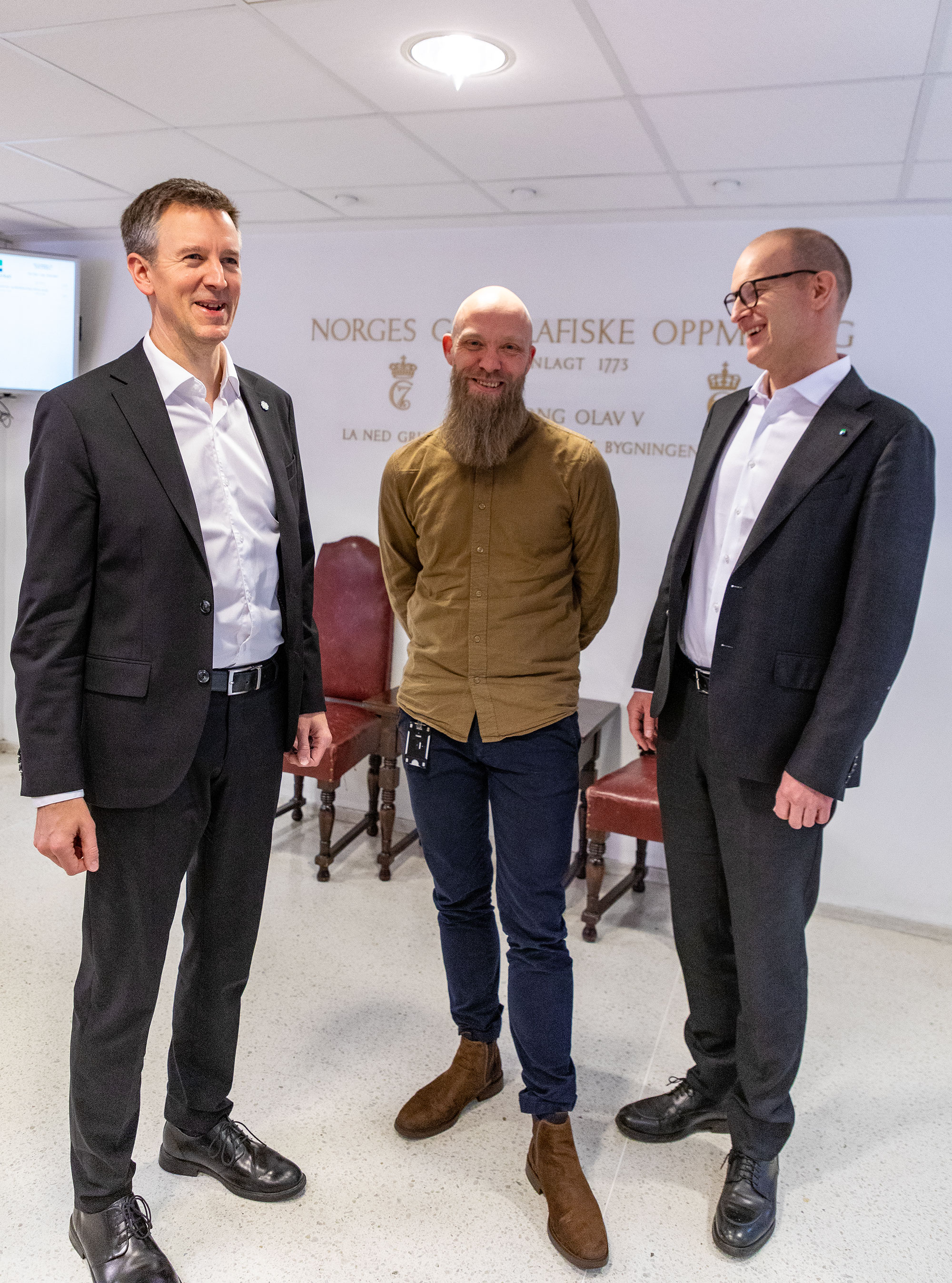 Tre menn i resepsjonen til Kartverket p&aring; H&oslash;nefoss. Foto: &Aring;sgeir St&oslash;rdal/Kartverket