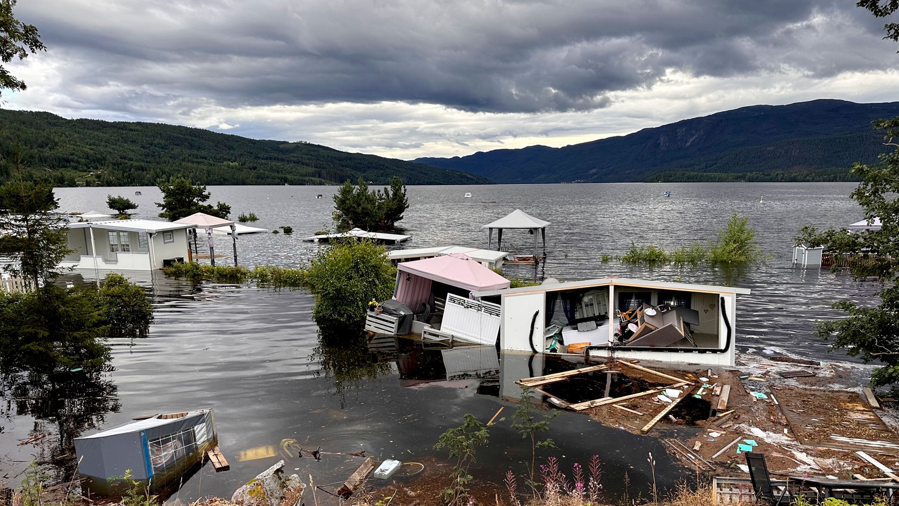 Campingvogner og spikertelt flyter i vannet etter flom ved Sperillen og Buttingsrud camping under ekstremværet Hans. (Foto: Åsgeir Størdal)