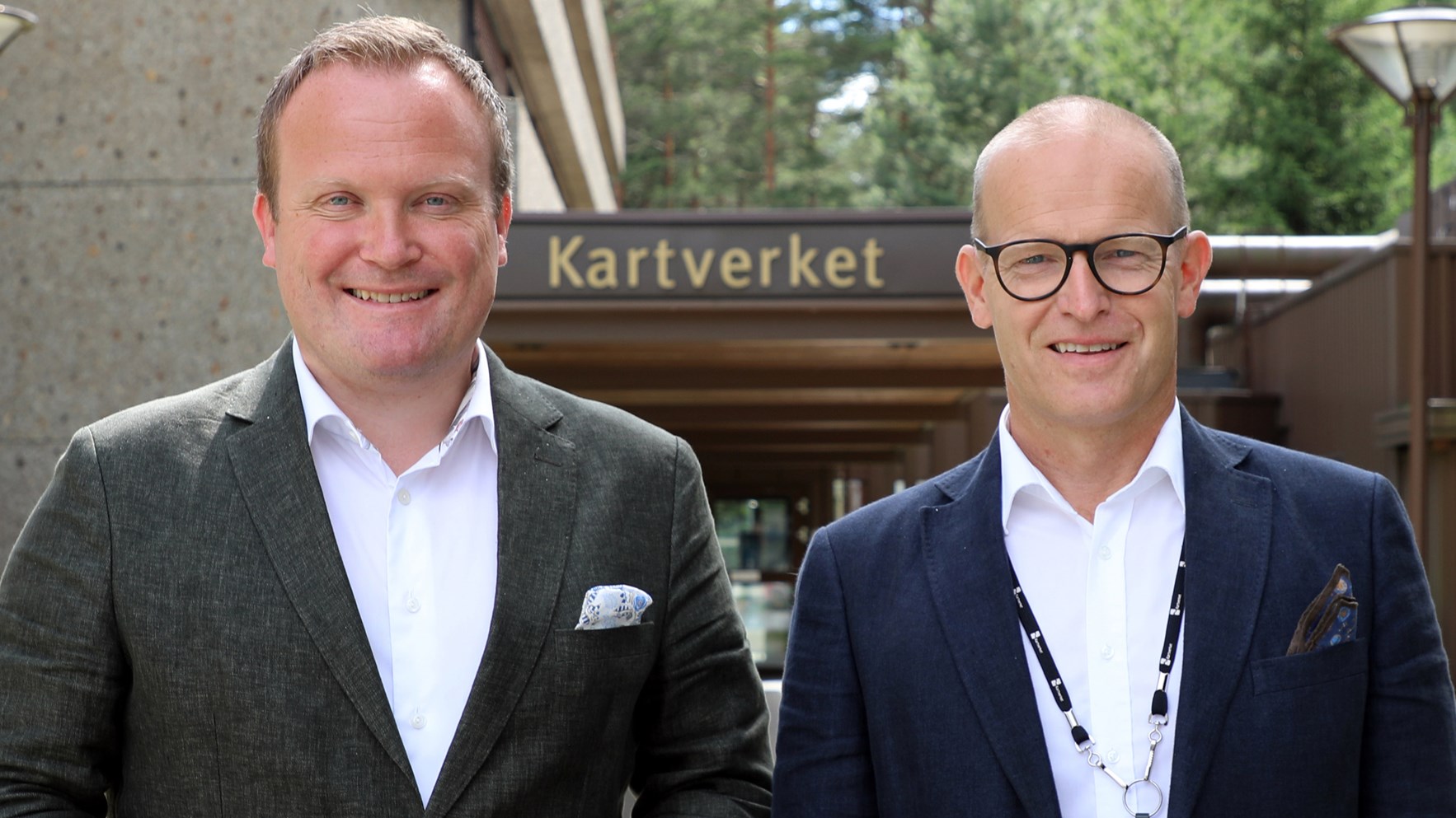Hans Petter Aasen og Johnny Welle står foran inngangen til Kartverkets hovedkontor på Hønefoss.