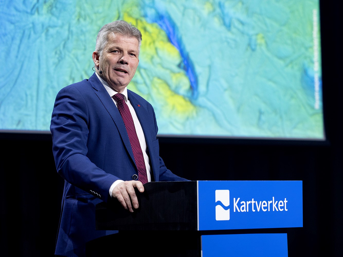 Statsr&aring;d Bj&oslash;rnar Skj&aelig;ran st&aring;r bak en talerstol og snakker p&aring; Kartverkskonferansen 2026.