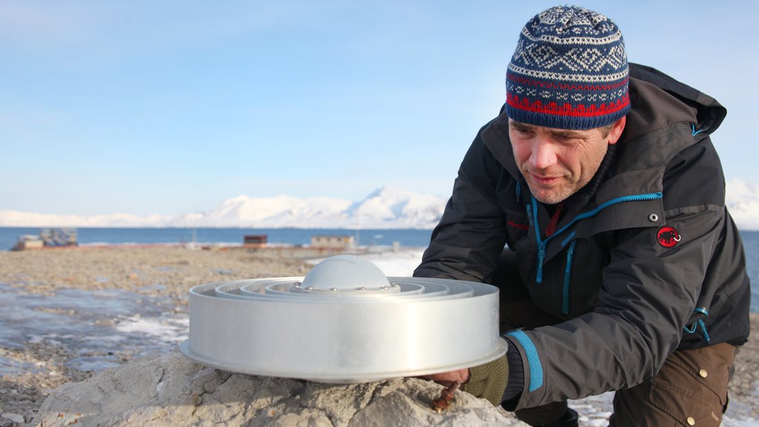 Forskar Halfdan P. Kierulf montrar GPS og antenne på ein knaus ved Kongsfjorden i Ny-Ålesund, Svalbard. Foto: Bjørn-Owe Holmberg