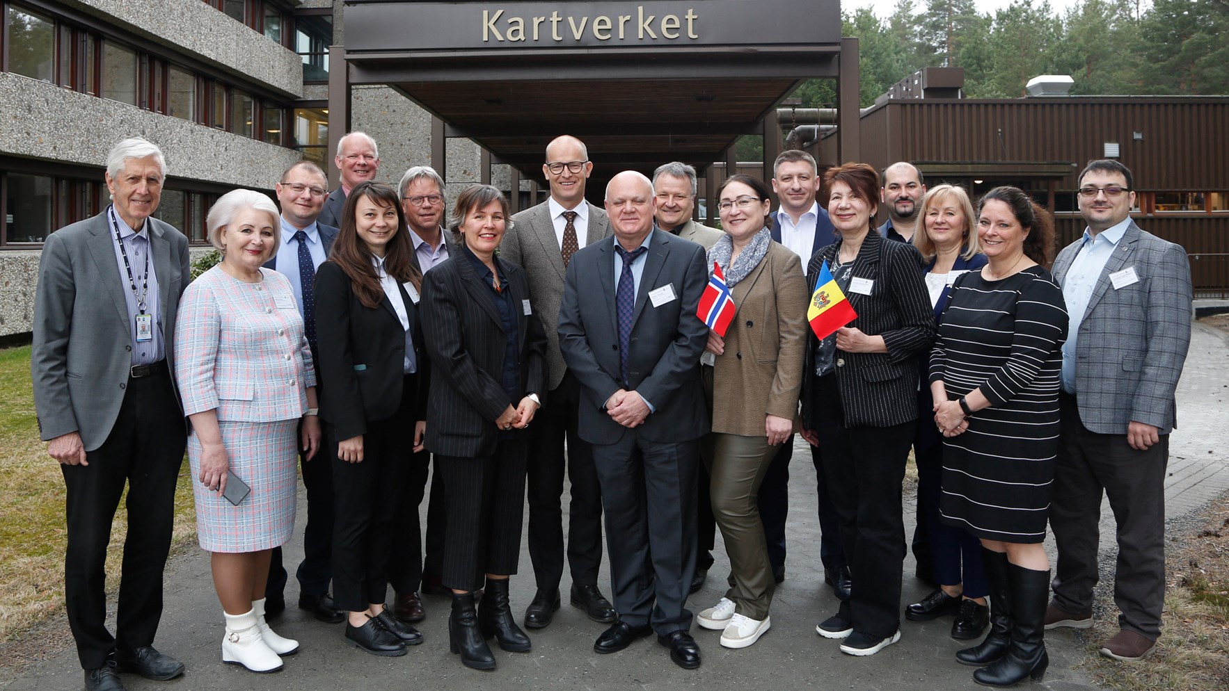 En stor gruppe mennesker står samlet foran hovedinngangen til Kartverket på Hønefoss.