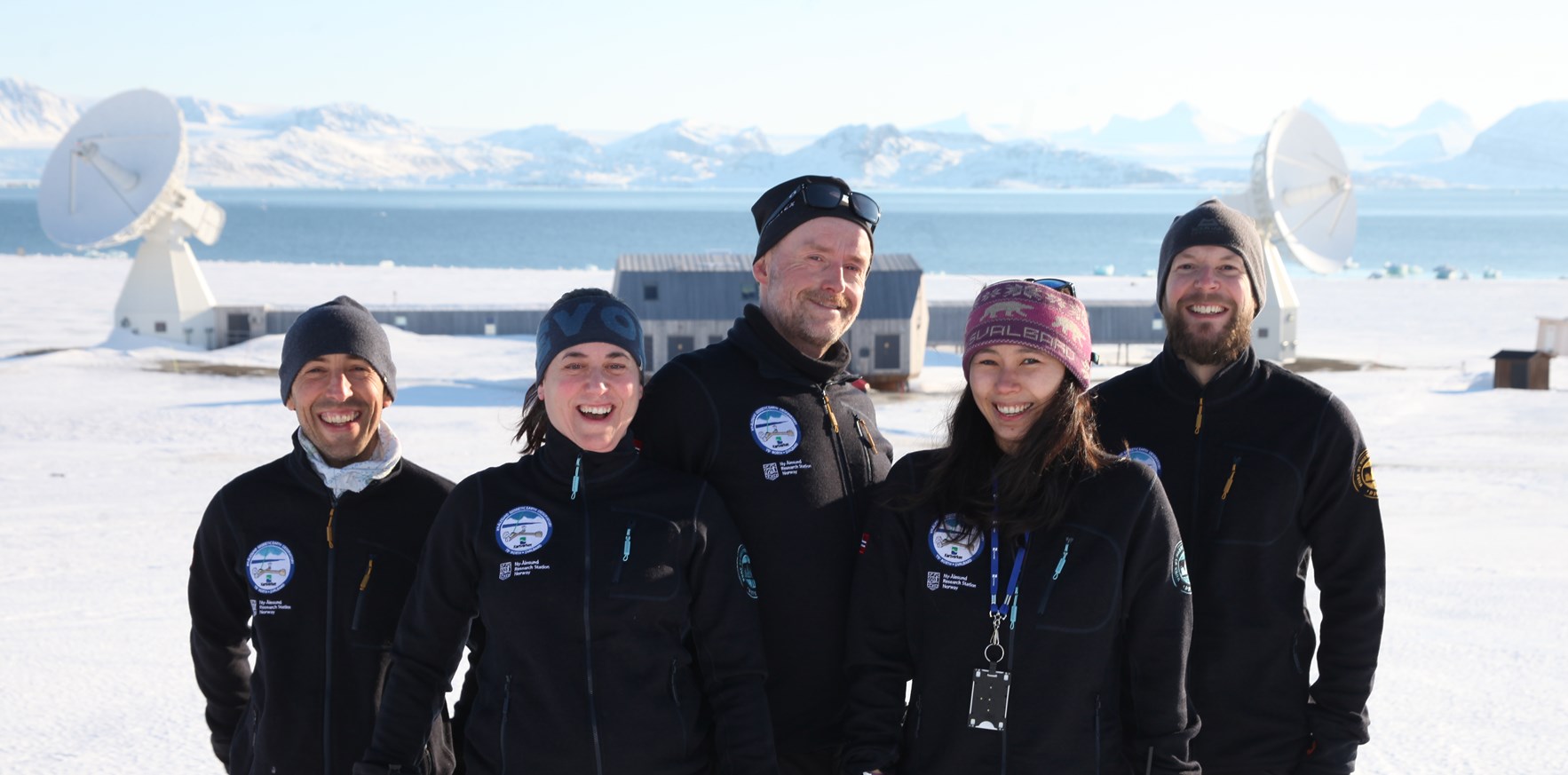 Fem personer foran Kartverkets jordobservatorium på Svalbard - Kartverkets team på Svalbard (foto: Bjørn-Owe Holmberg)