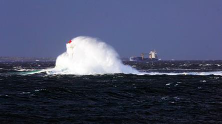 Bølge som slår opp rundt fyrlykt. Foto: Rune Nylund Larsen/ Kystverket