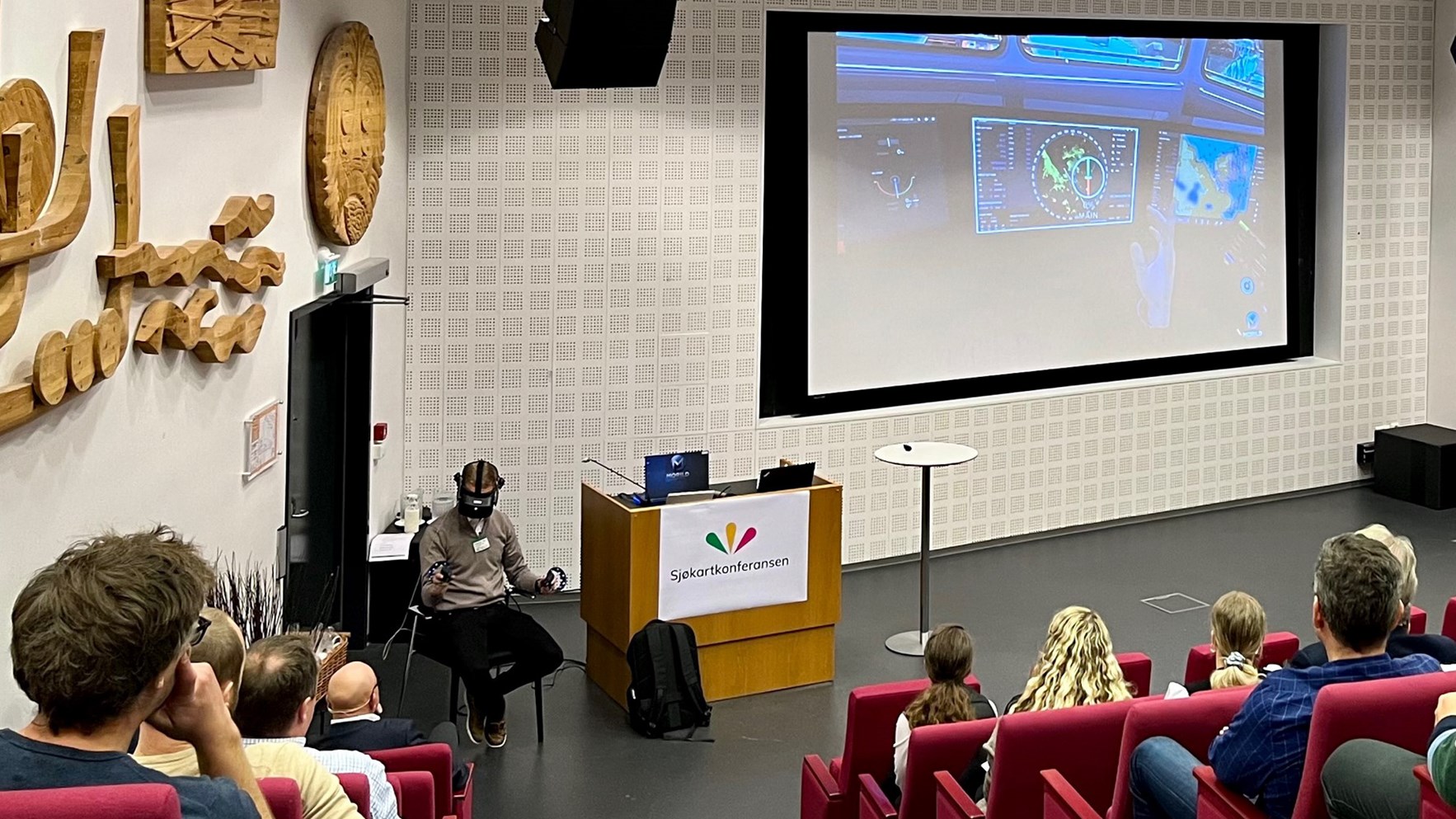 Odd Sveinung Hareide demonstrerer VR-briller brukt til å trene statsloser. Foto.