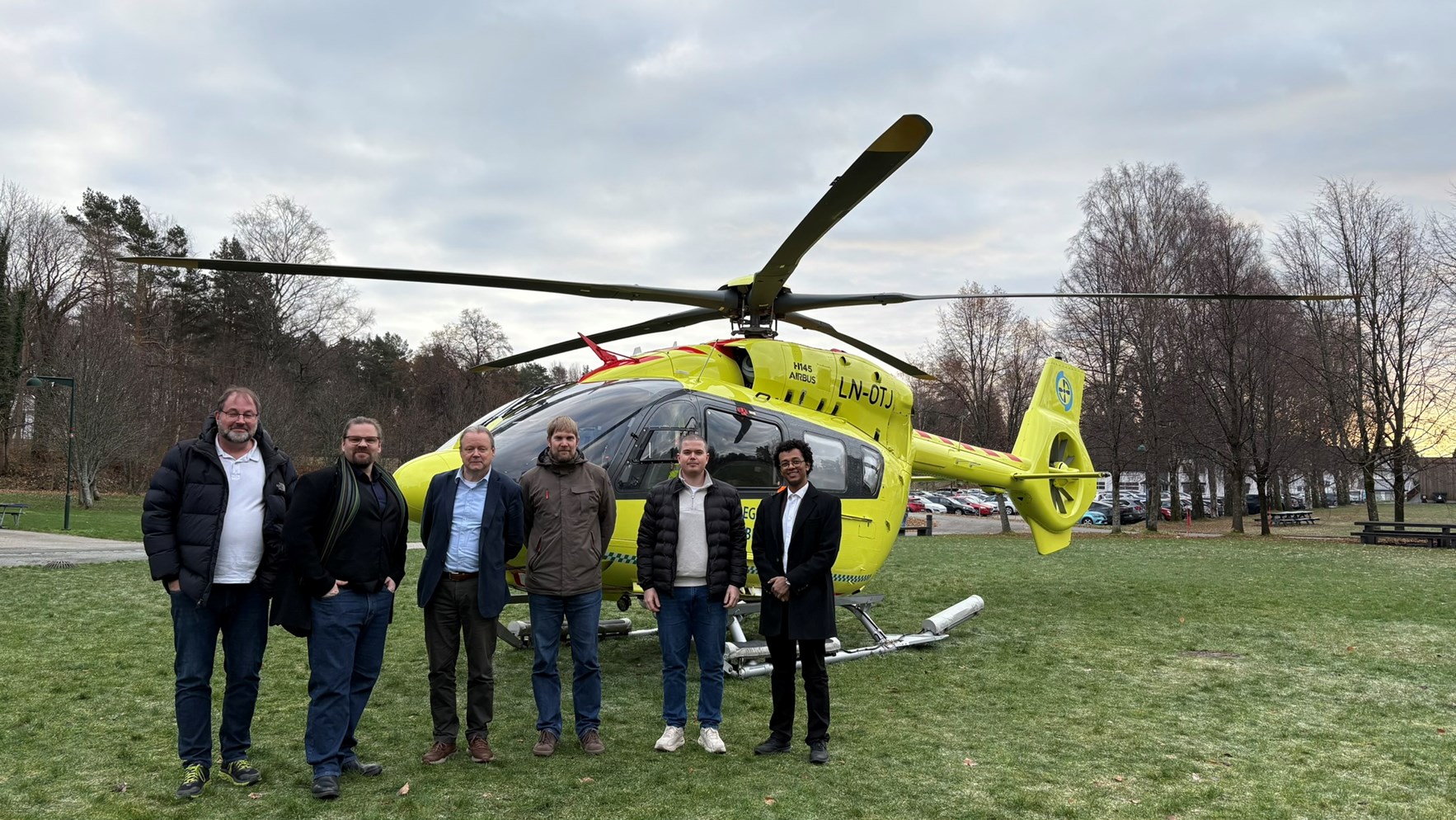 Menn foran et parkert ambulsansehelikopter