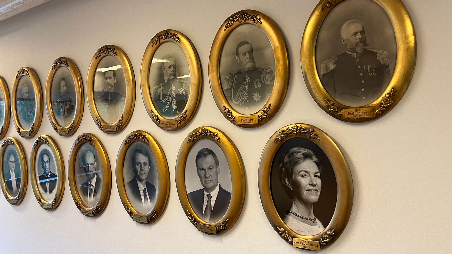 Vegg dekorert med foto av tidligere kartverkssjefer