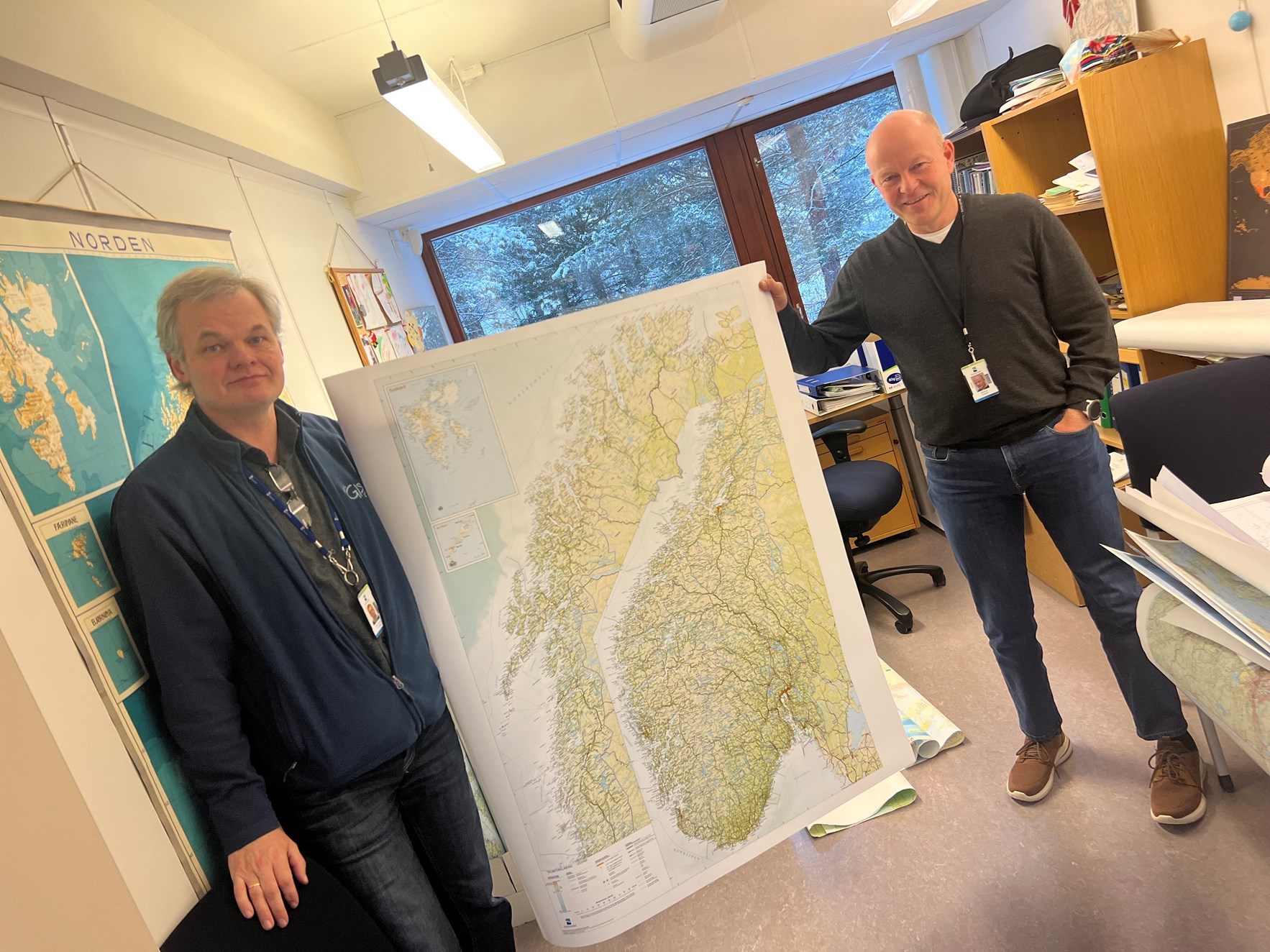 To ansatte ved Kartverket holder opp et kart