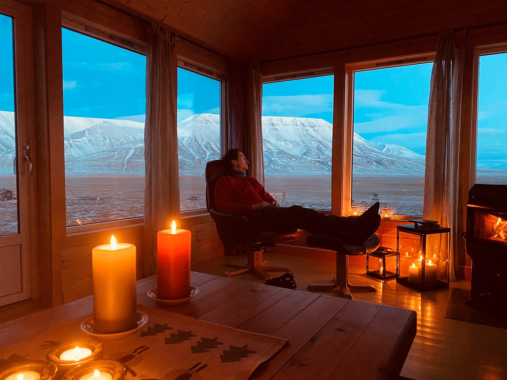 Utsikt over Adventdalen fra koselig hytte med stearinlys