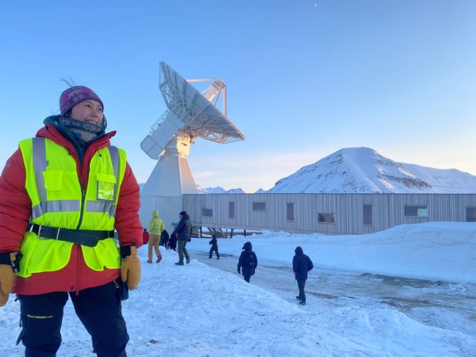 Silje Grøslie Wennesland foran Kartverkets geodetiske stasjon på Svalbard.